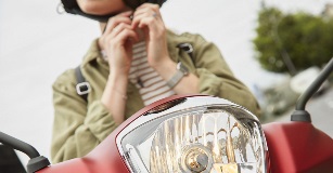 Moto On devine les mains d'une femme sur une moto qui accroche son casque